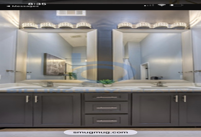 Full bath featuring double vanity and light wood-style flooring