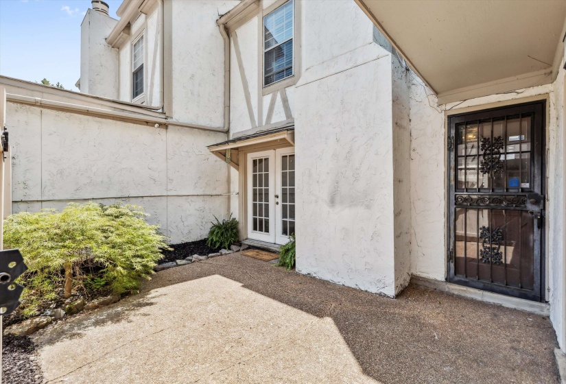 Property entrance with french doors, a patio, and stucco siding