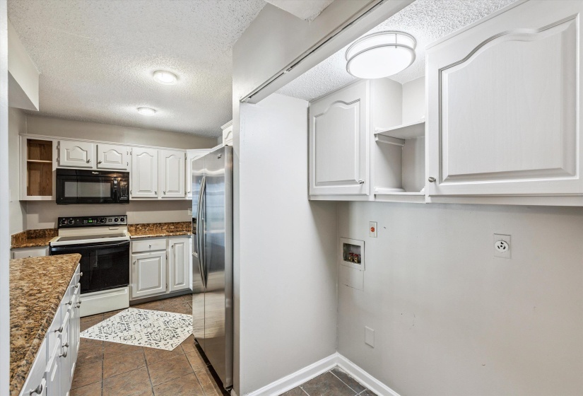 Kitchen with open shelves, white electric stove, a textured ceiling, stainless steel refrigerator with ice dispenser, and black microwave