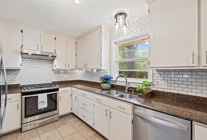 Kitchen featuring white cabinetry, brown countertops, and subway tile backsplash
