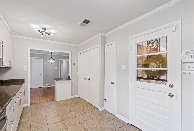 Kitchen featuring wood-finish cabinetry, dark countertops, and tile flooring