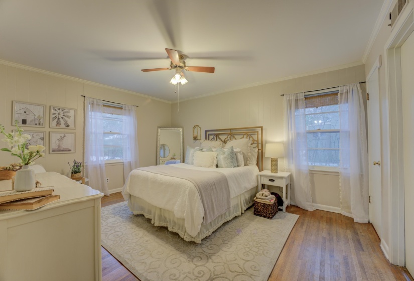 Hardwood flooring and crown molding define this bedroom