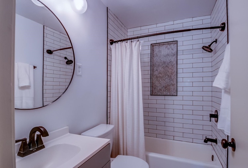 Bathroom featuring vanity and shower / bath combination with curtain