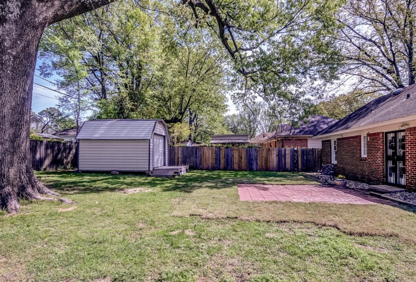 Fenced backyard with a patio area and a storage shed