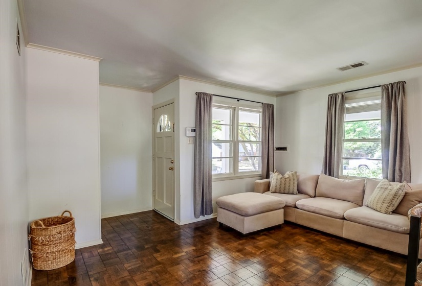 Living room with ornamental molding and parquet flooring