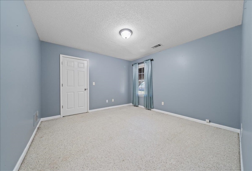 Unfurnished room with a textured ceiling and carpet floors