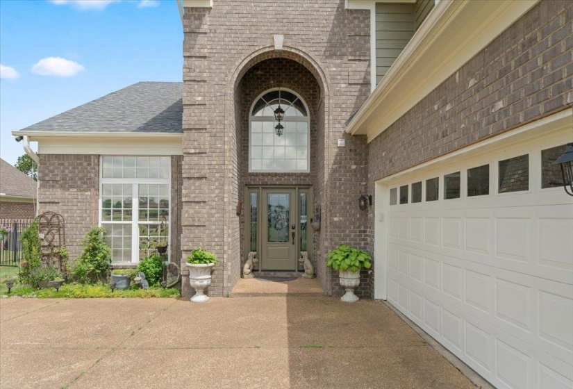 Brick exterior featuring an arched entryway with a transom window