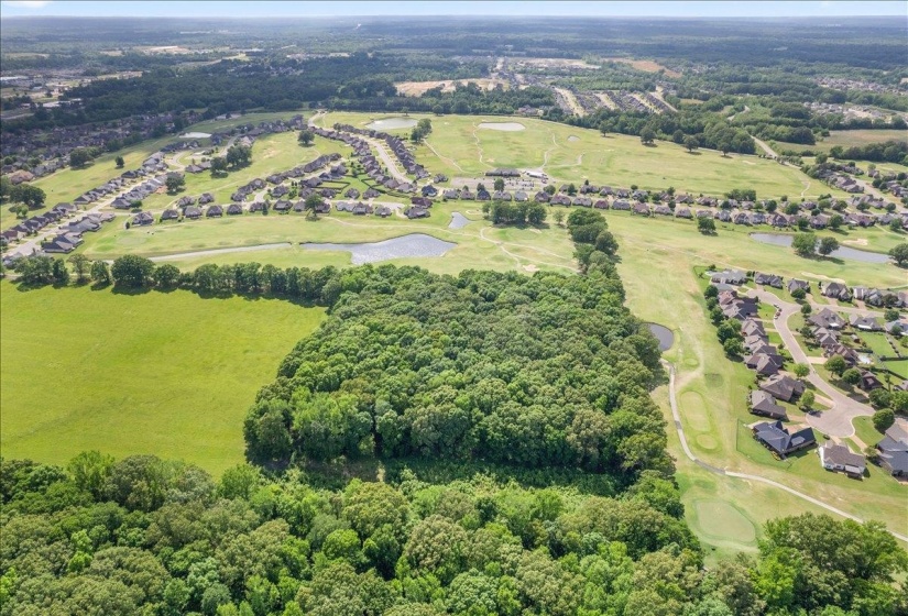 Aerial overview of property's location with a local golf course and nearby suburban area