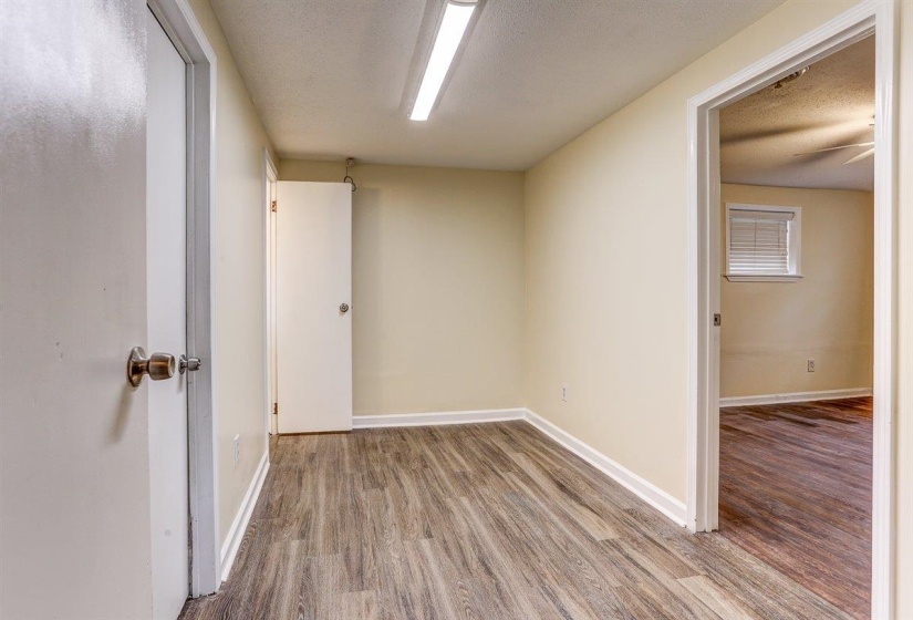 Empty room with wood finished floors and a textured ceiling