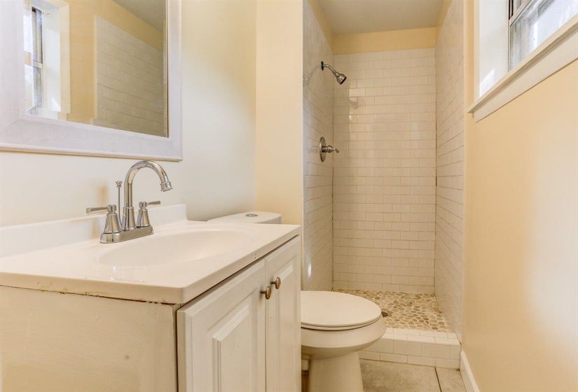 Full bathroom featuring healthy amount of natural light, vanity, and a shower stall