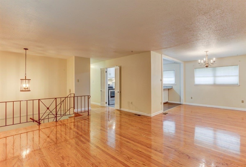 Spare room featuring a chandelier, light wood-style flooring, and a textured ceiling