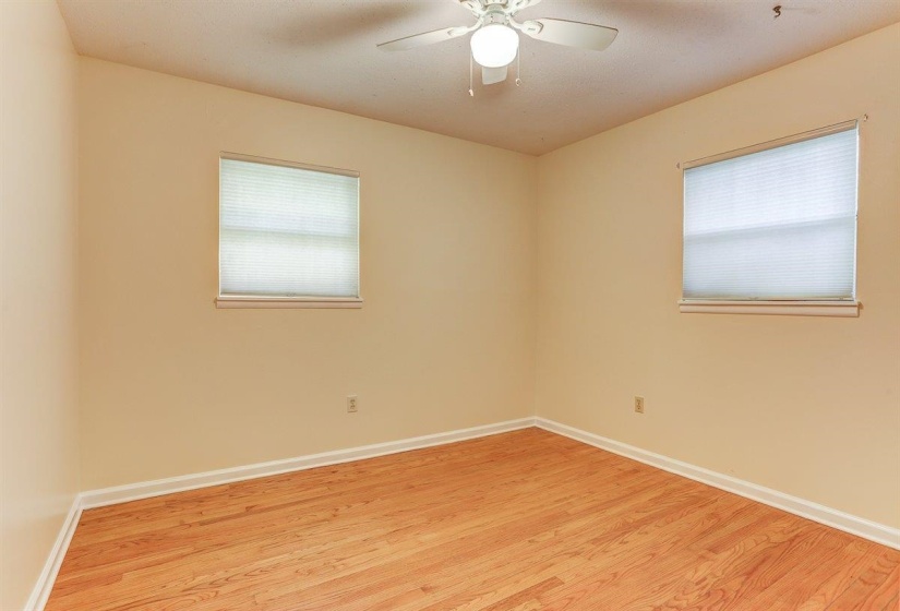 Empty room with light wood finished floors and ceiling fan