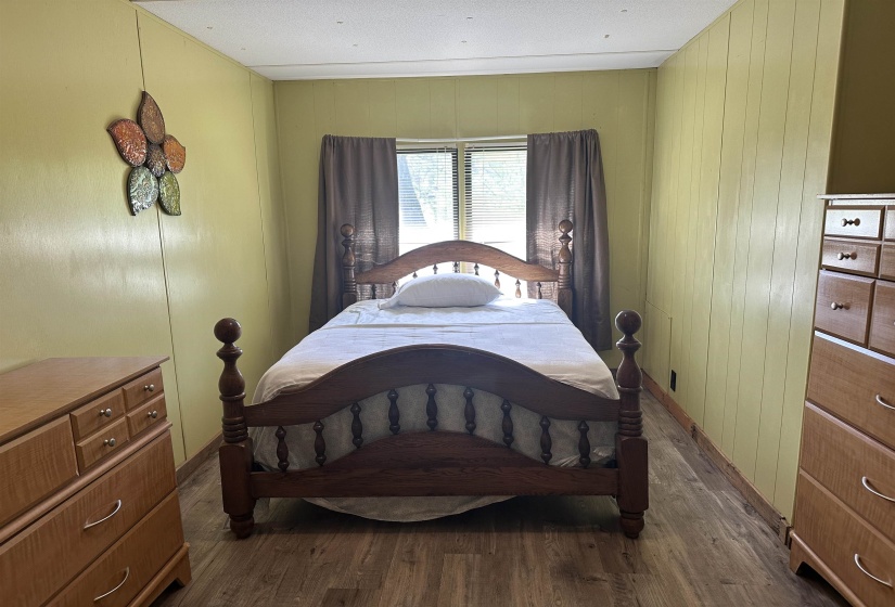 Bedroom featuring dark wood-type flooring and baseboards
