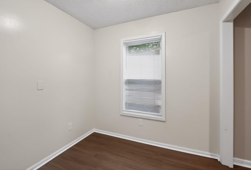 Unfurnished room featuring dark wood finished floors and a textured ceiling