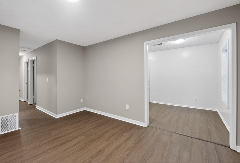 Empty room featuring baseboards and dark wood-style flooring