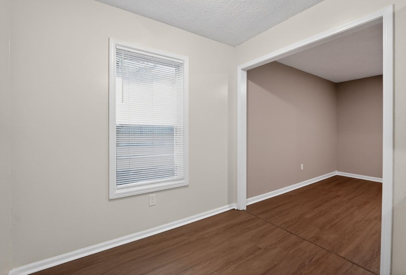 Empty room featuring dark wood-style flooring and a textured ceiling