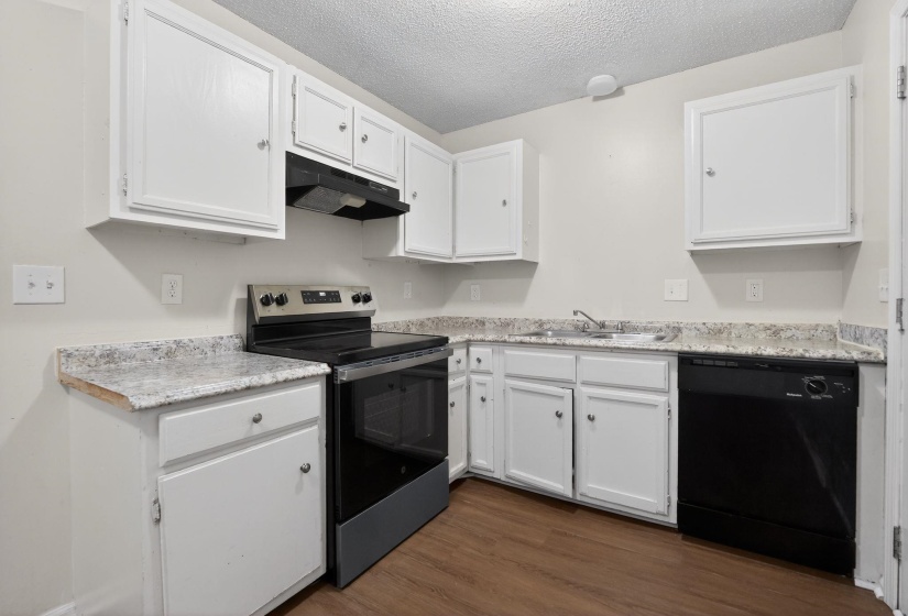 Kitchen featuring stainless steel range with electric cooktop, white cabinets, dishwasher, light countertops, and a textured ceiling