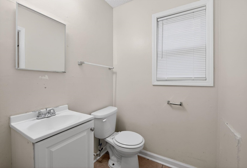 Half bathroom with vanity and toilet