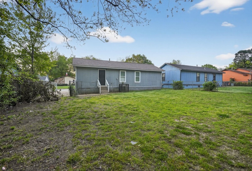 Rear view of property with a fenced backyard, crawl space, and a gate