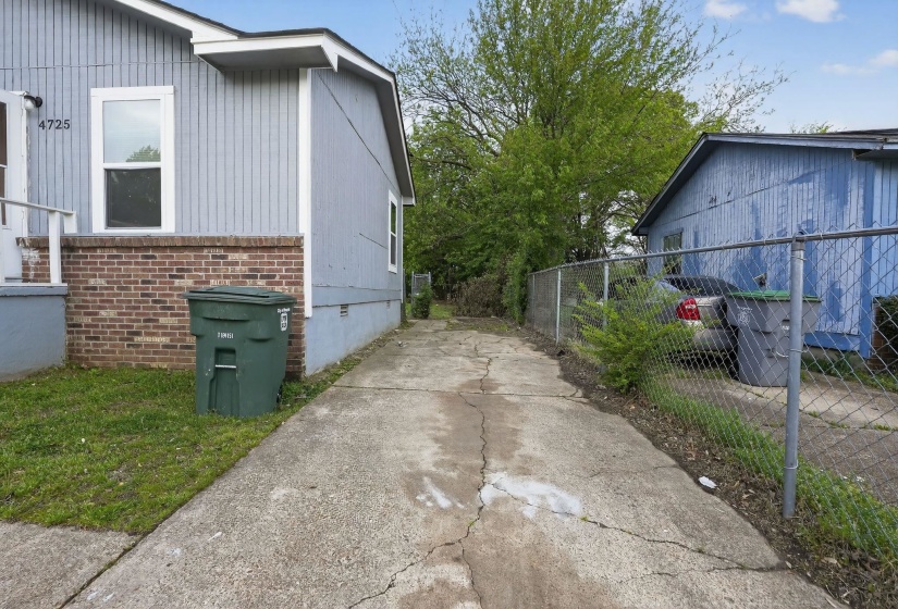 View of side of property featuring crawl space, driveway, and brick siding