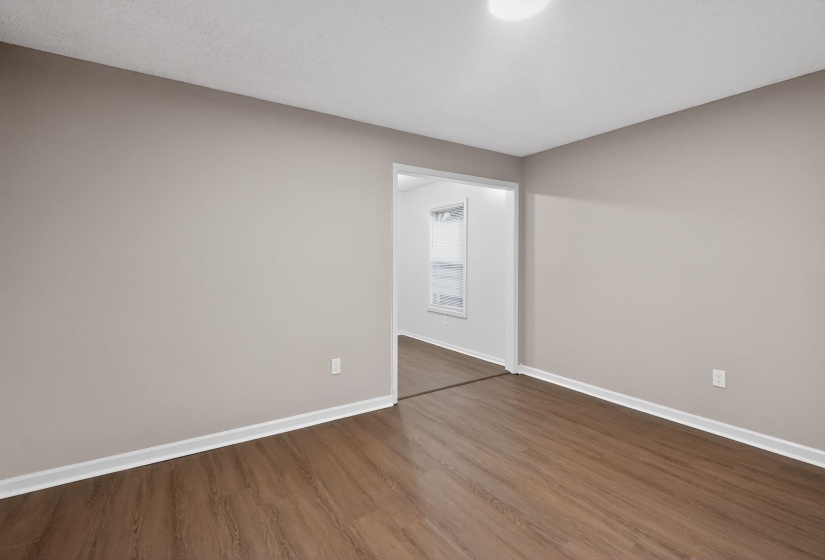 Empty room featuring baseboards and dark wood-style floors