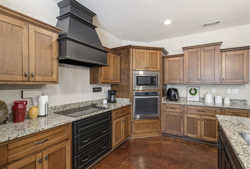 Kitchen featuring stainless steel appliances, finished concrete flooring, and wood finish cabinets