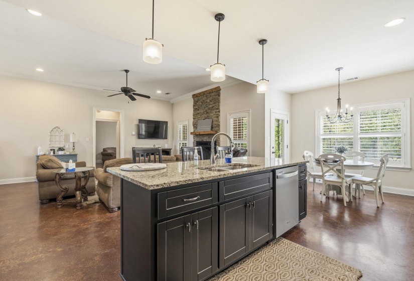 Kitchen featuring finished concrete flooring, open floor plan, a fireplace, and a center island with sink