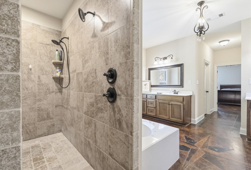 Bathroom featuring vanity, a walk in shower, and a garden tub