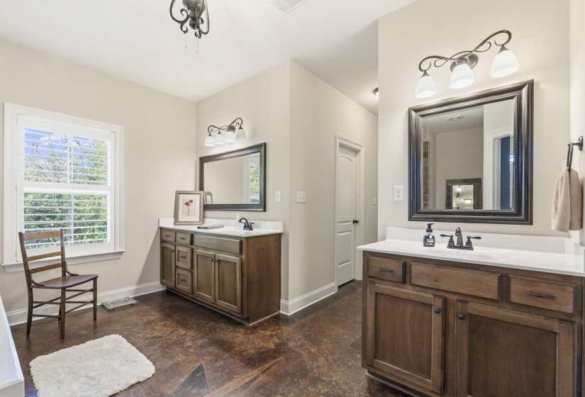 Full bathroom featuring two vanities and baseboards