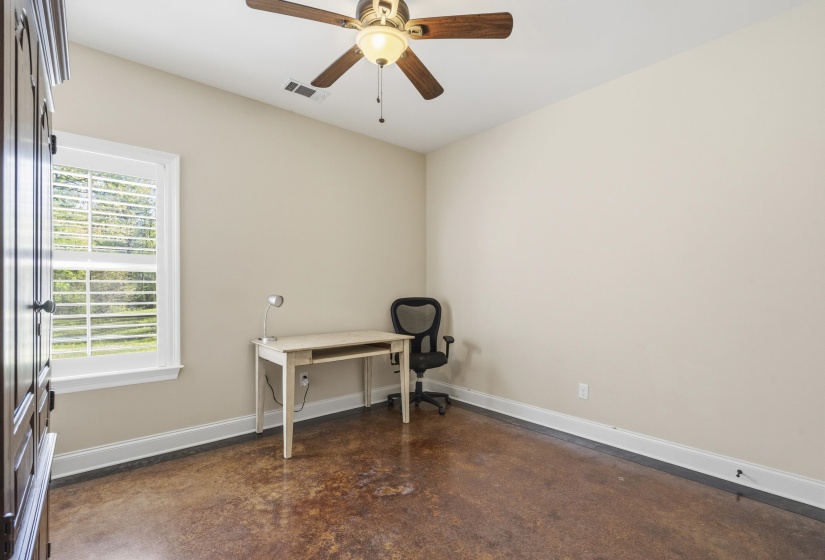 Unfurnished office with finished concrete floors and a ceiling fan