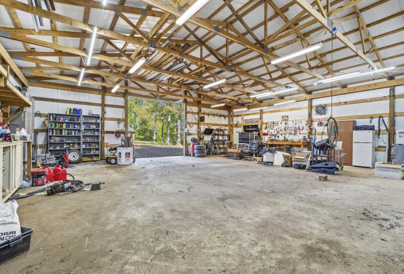 Garage featuring a workshop area and freestanding refrigerator