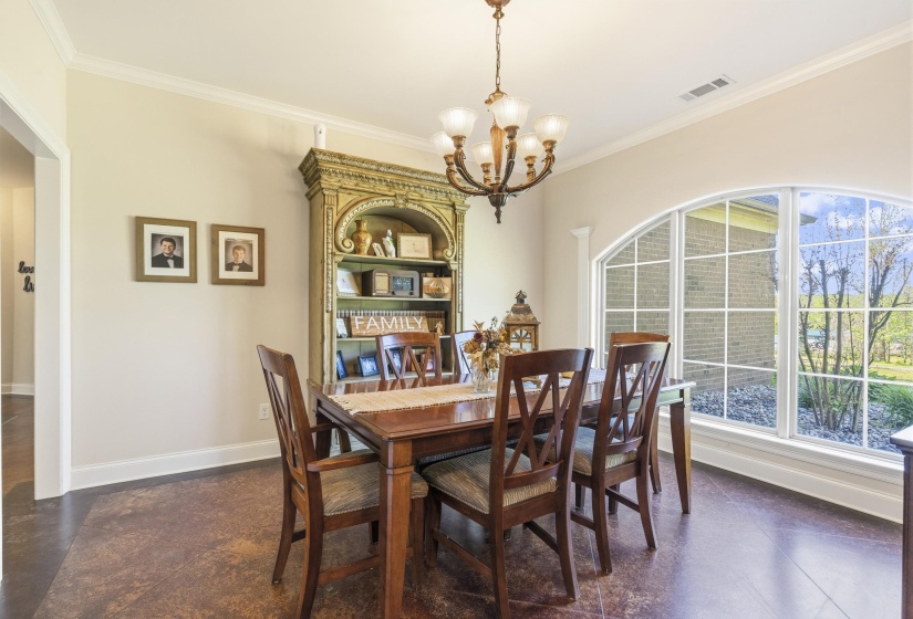Dining space with ornamental molding and suspended lighting