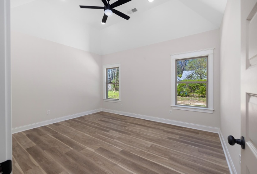 Spare room featuring a ceiling fan, dark wood-style floors, lofted ceiling, healthy amount of natural light, and recessed lighting