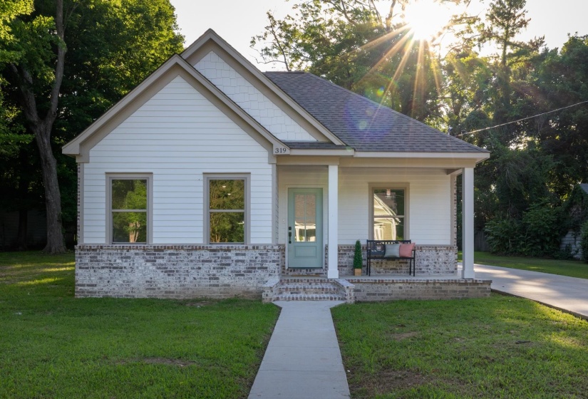 White siding exterior with a light brick foundation