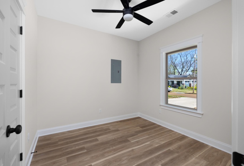 Unfurnished room featuring dark wood-style flooring, electric panel, and a ceiling fan