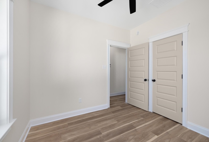 Unfurnished bedroom with light wood-style floors, a ceiling fan, and a closet