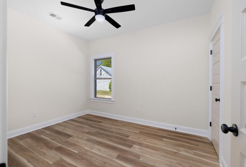 Empty room featuring light wood-type flooring and a ceiling fan