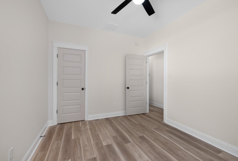 Unfurnished bedroom with light wood finished floors, a closet, and a ceiling fan