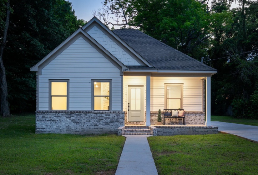 Charming single-story residence featuring light-colored horizontal siding and a dark shingle roof