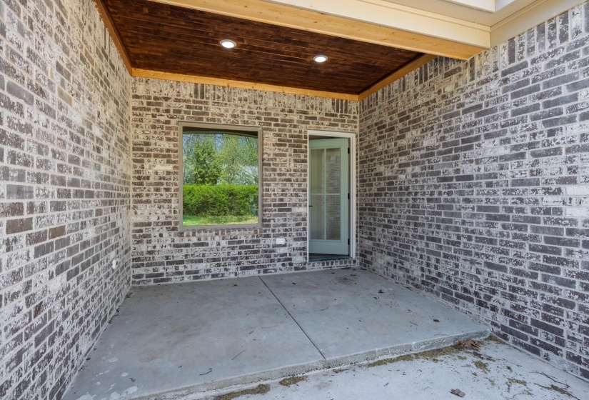 View of exterior entry with a patio and brick siding