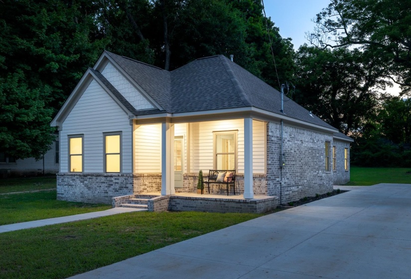 Cottage-style residence featuring a combination of horizontal siding and painted brickwork