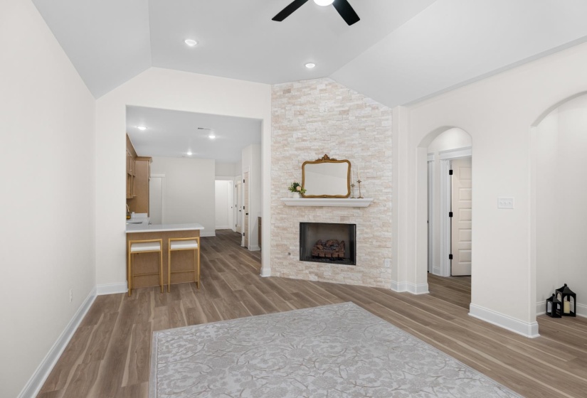 Living area with a stone-clad fireplace and wood-finish flooring