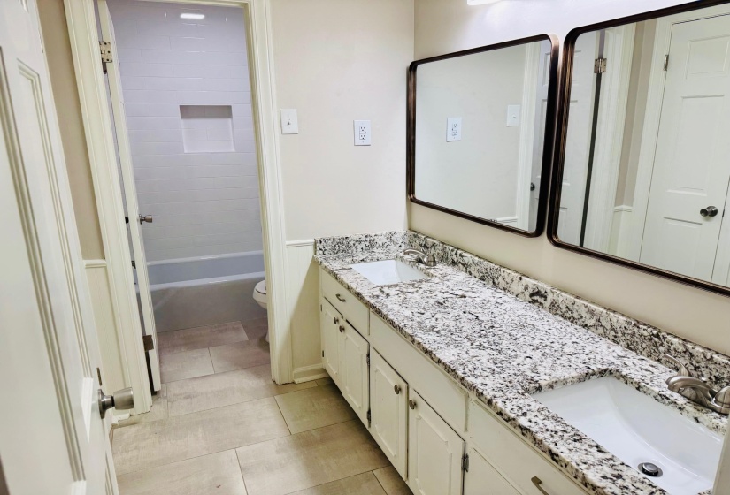 Full bathroom with vanity, toilet, tiled shower / bath combo, and tile patterned flooring