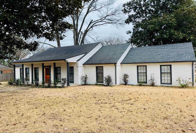 Single story home with a porch and a front yard