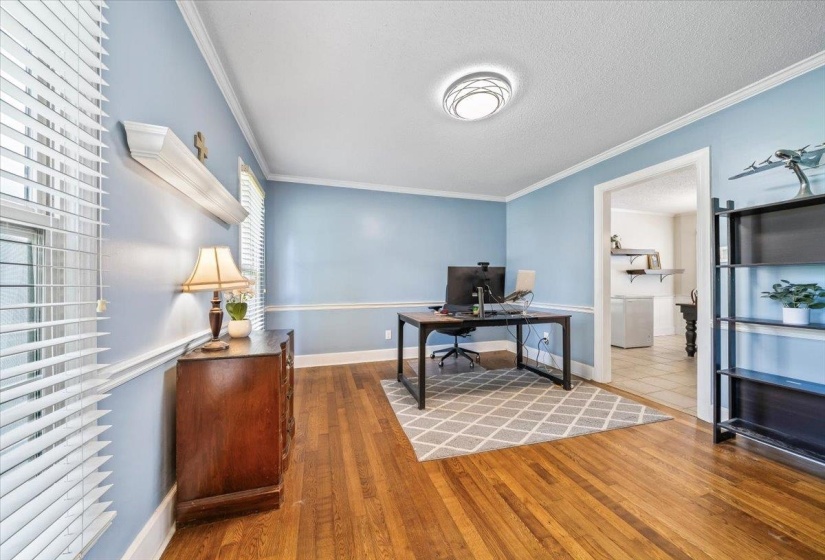 Office area featuring wood finished floors, crown molding, and a textured ceiling