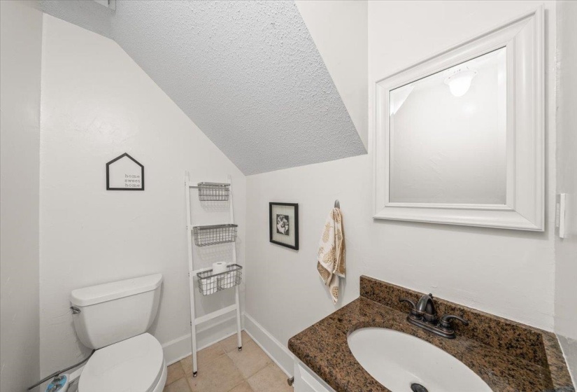 Bathroom featuring vanity, lofted ceiling, and a textured ceiling