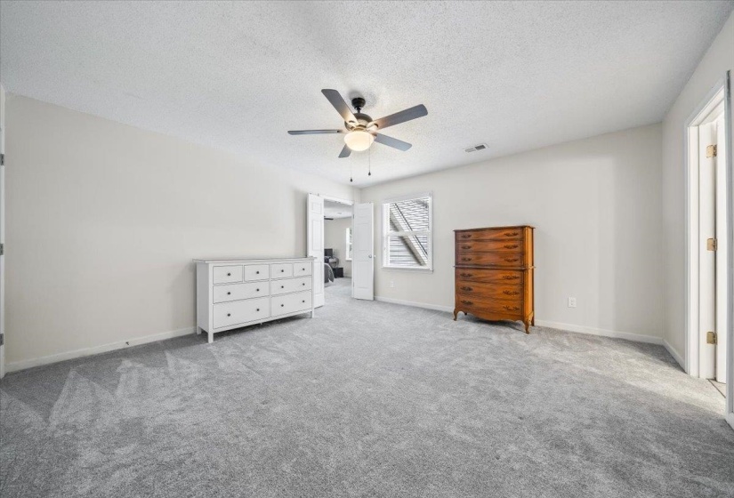 Unfurnished bedroom with carpet flooring, a textured ceiling, and a ceiling fan