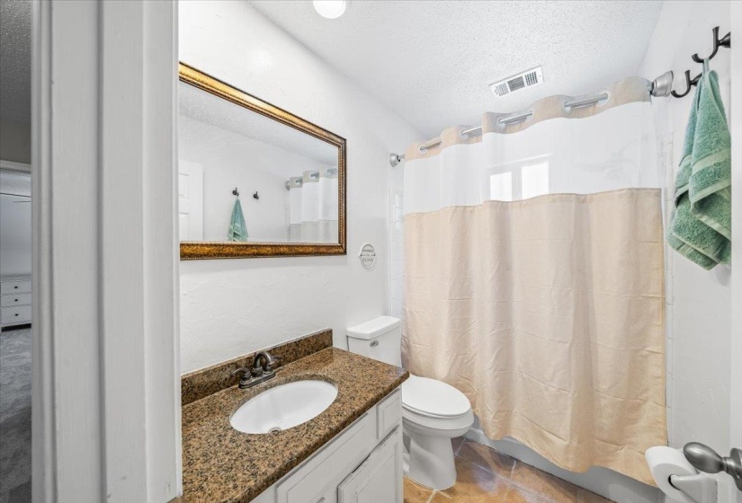 Bathroom with a textured ceiling, vanity, and tile patterned floors