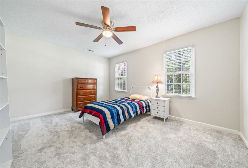 Carpeted bedroom featuring baseboards and ceiling fan