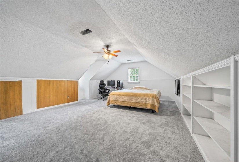Bedroom with a textured ceiling, carpet floors, lofted ceiling, and a ceiling fan